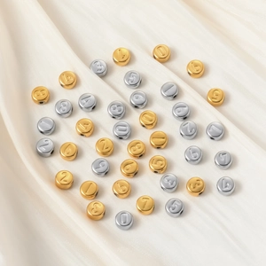 Detailed macro of gold and silver number beads on satin for DIY jewelry making