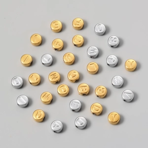 Macro shot of 7mm titanium steel letter beads in gold and silver for DIY jewelry making