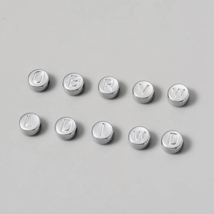 Macro detail of 7mm silver titanium steel alphabet beads for DIY jewelry making