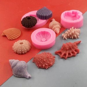 Pink silicone molds for seashell and starfish chocolates on a red and grey background