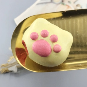 Cat paw shaped silicone mold with yellow and pink resin detailing on a gold metal tray