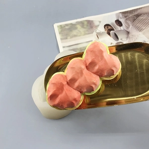 Three-tier heart silicone mold and finished pink candle on gold decorative tray