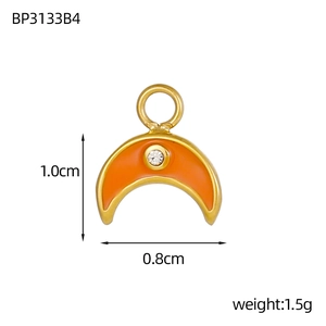 Detailed view of crescent moon pendant in gold with orange enamel and cubic zirconia