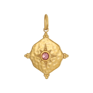 Macro detail of gold plated geometric charm with pink gemstone and hammered metal texture