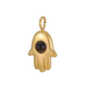 Pendentif main de Fatma dorée avec pierre centrale sur fond blanc, accessoire de mode