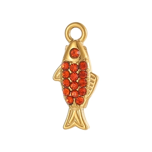 Macro view of a gold-plated fish pendant featuring micro-set red crystals and circular hook