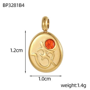 Macro detail of a 1.2cm gold stainless steel Om pendant with an orange zircon stone