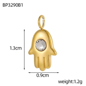 Detail view of a 1.3cm x 0.9cm gold Hamsa Hand pendant with a sparkling zircon inlay