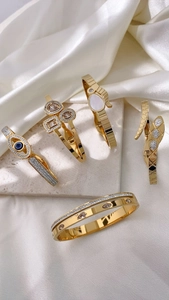 Detail of gold snake bracelets with evil eye charms and rhinestones on silk
