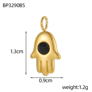 Macro shot of gold Hamsa Hand pendant with black gemstone showing 1.3cm height scale