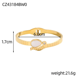 Detail view of a gold snake-shaped spring bracelet with shell inlay and size markings
