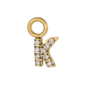 Détail macro d'un pendentif lettre K doré avec sertissage de zircons brillants