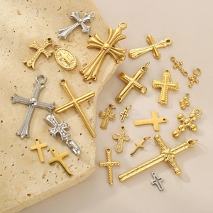 Retro stainless steel cross pendants in gold and silver finish on stone display