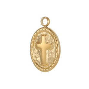 Macro detail of oval gold-plated cross pendant with vintage relief and ray textured edge