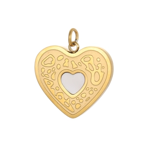 Primer plano del colgante corazón dorado con incrustación blanca y grabados calados