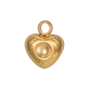 Détail du pendentif en forme de cœur doré avec surface en métal martelé texturé
