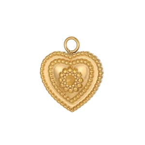 Vue macro d'un pendentif cœur doré avec texture perlée rétro et détails en relief floral