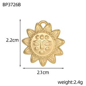 Detail view of a vintage gold sun pendant with face relief and 2.2cm size measurement