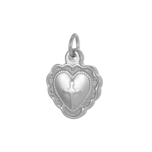 Macro detail of silver heart pendant with embossed cross and lace edge texture