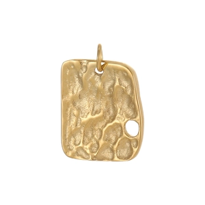 Detail of a golden hammered rectangular pendant with a textured vintage surface and ring hole