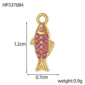 Detail van gouden vis hanger met afmetingen van 1,2 cm hoogte en roze kristallen