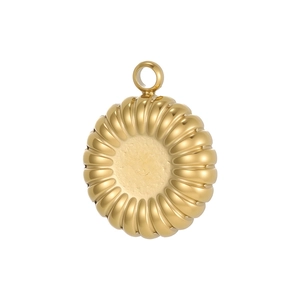 Detail of a vintage golden sunburst stainless steel pendant with radial wave texture