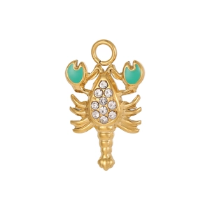 Macro shot of golden lobster pendant with green enamel claws and sparkling zircons