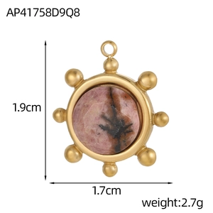 Dettaglio del ciondolo a sole irregolare dorato con pietra rosa, misura 1.9cm x 1.7cm