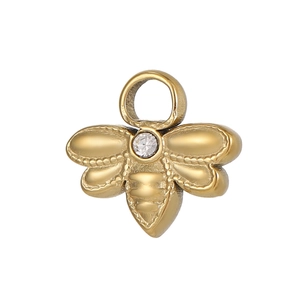 Détail macro d'un pendentif abeille en or mat avec une pierre précieuse claire brillante