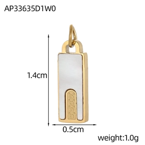 Detailweergave van een gouden geometrische hanger met witte schelp en dot-versiering