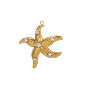 Macro shot of gold starfish pendant with inlaid pearls and fine bead texture detail