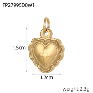 Macro shot of 1.5cm gold heart pendant with cross relief and scalloped edge detail
