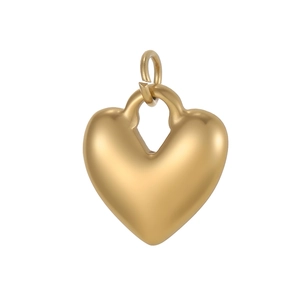 Detalle macro del colgante dorado con forma de corazón, acabado mate y anilla superior