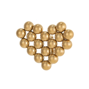 Vista macro de charm de corazón con cuentas doradas y clip metálico trasero
