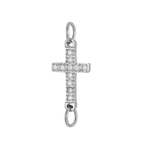 Detalle de colgante de cruz plateada con circonitas micro-pave y dos anillos de conexión