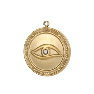 Detail of a vintage golden evil eye round pendant with a small center crystal stone