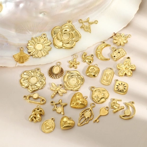 Assorted gold plated DIY jewelry pendants featuring mushroom and sun designs on shell