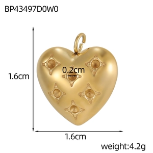 Macro detail of heart-shaped pendant in matte gold finish with star engraving