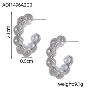 Close-up of C-shaped hoop earrings with silver striped beads and faux pearls