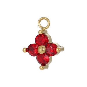 Detailed view of a gold flower pendant with four faceted red gemstones and metallic beads