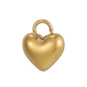 Detailopname van gepolijste gouden hartvormige hanger met spiegelende afwerking