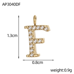 Détail du pendentif doré lettre F orné de pierres de zircone blanches fines