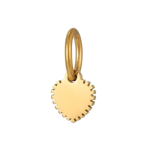 Détail d'un pendentif cœur doré avec bords dentelés et finition métallique polie