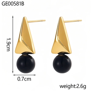 Vista detallada de los pendientes de triángulo dorado con cuentas negras y medidas de 1,9 cm
