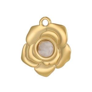 Détail d'un pendentif en forme de rose dorée serti d'une pierre précieuse translucide