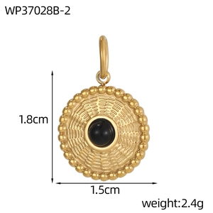 Detailansicht eines goldenen Vintage-Anhängers mit schwarzem Stein und Sonnenstrahlmuster