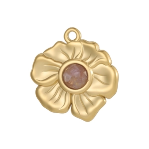 Détail macro d'un pendentif fleur doré avec cinq pétales et une pierre précieuse violette