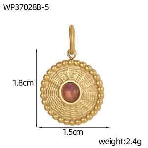 Detail eines runden Vintage-Edelstahlanhängers mit rosa Edelstein und goldener Oberfläche