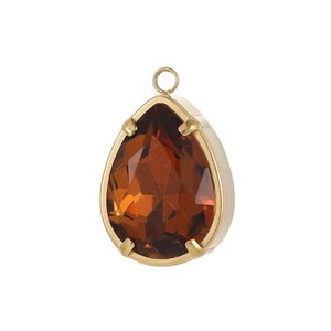 Macro-opname van een druppelvormige hanger van amberkleurig zirkoon in goud