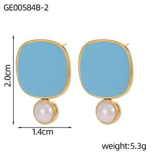 Detalle de pendientes de esmalte azul claro con perla blanca y borde de metal dorado